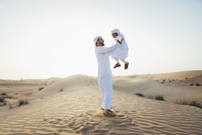 Man standing on sand against clear sky