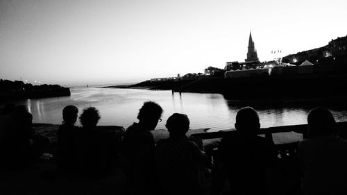 Silhouette of people in front of lake