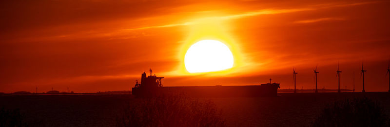 Scenic view of sea against orange sky