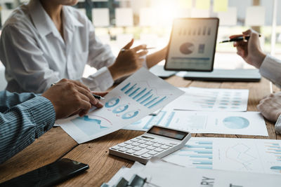 Midsection of businessman working on table