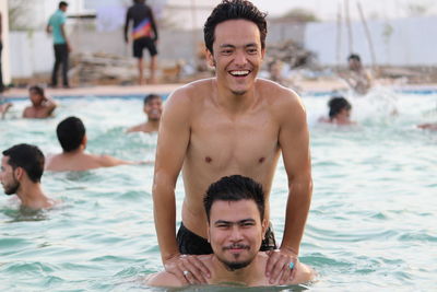 Smiling friends swimming in pool