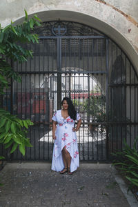 Woman standing against metal gate