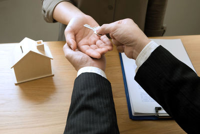 High angle view of man holding hands on table