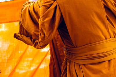 Midsection of monks wearing traditional clothing while standing outdoors