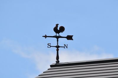 Low angle view of weather vane on roof