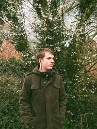 Portraits of young man standing by a tree