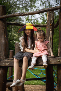 Portrait of two girls in a belgian flag hat in the park.