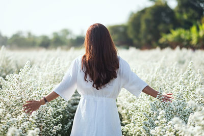 Rear view of woman standing on field