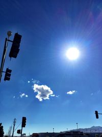 Low angle view of sun shining through clouds