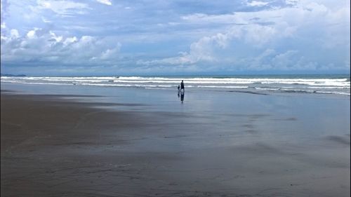 Silhouette man on beach against sky