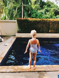 Full length of woman standing in swimming pool