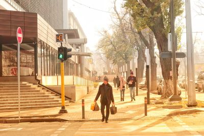 Rear view of man walking on footpath
