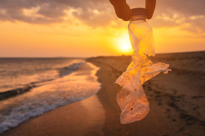 Low section of woman standing on sand at beach