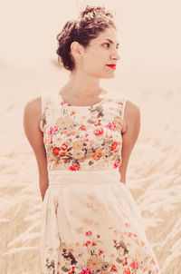 Young woman looking away while standing on beach