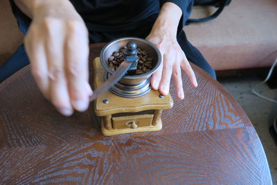 High angle view of person grinding coffee on table