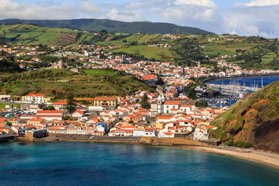 Scenic view of town by sea and mountains