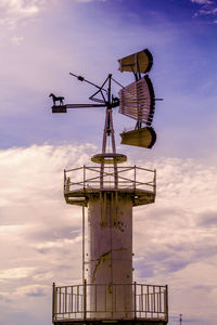 Low angle view of windmill against cloudy sky