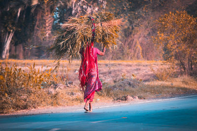 Woman carrying hay on head