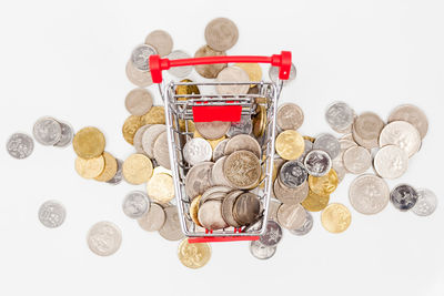 High angle view of coins on glass against white background