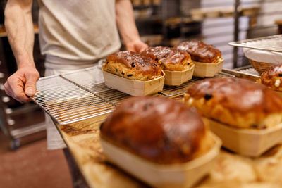 Midsection of baker binging breads 