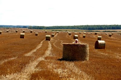 Hay bales on field against sky