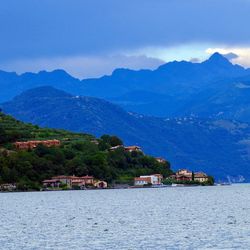 Scenic view of lake and mountains against blue sky