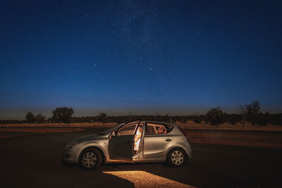 Car on road against clear sky at night