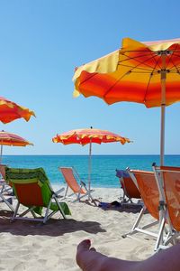 Umbrellas on beach against clear sky