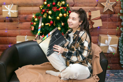 Portrait of young woman sitting on sofa at home