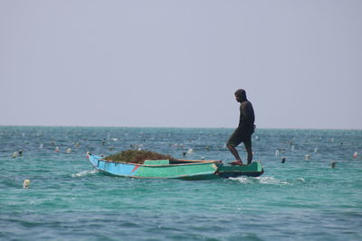 Man on sea against clear sky