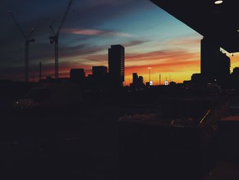 Silhouette city against sky at sunset