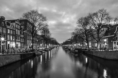 Canal amidst buildings against sky