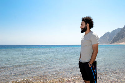 Man standing at beach against sky