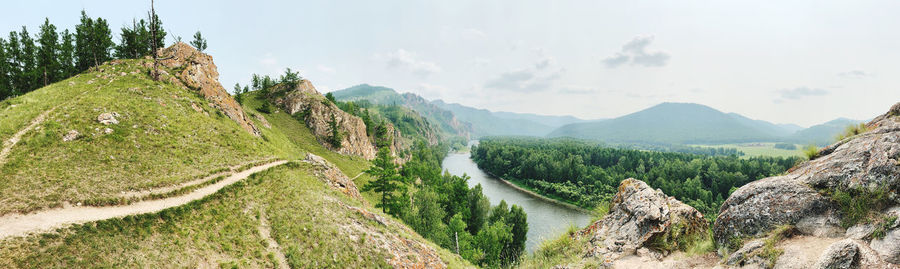 Panoramic view of green landscape against sky