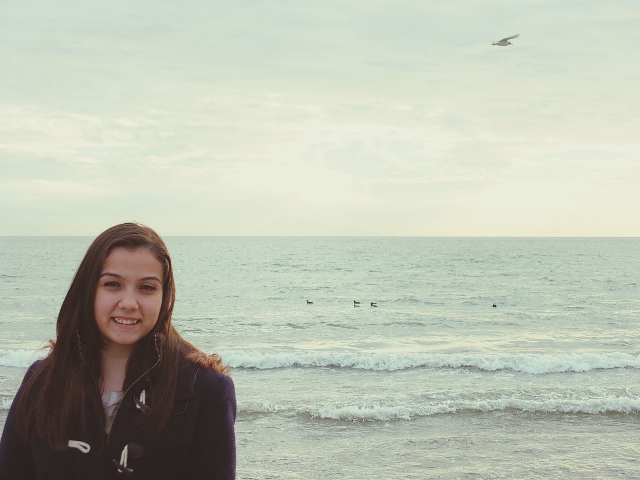 sea, lifestyles, leisure activity, young adult, person, horizon over water, water, beach, young women, sky, looking at camera, portrait, smiling, vacations, beauty in nature, headshot, scenics, casual clothing