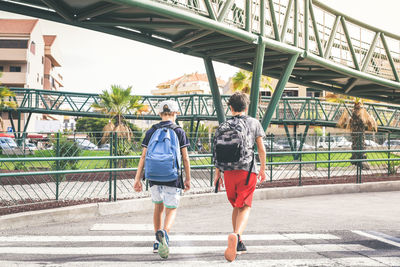 Rear view of women walking on footbridge