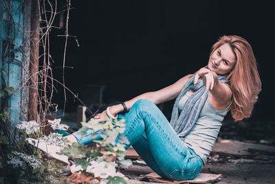 Portrait of beautiful young woman sitting outdoors