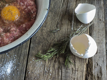 High angle view of minced meat and egg yolk in bowl at table