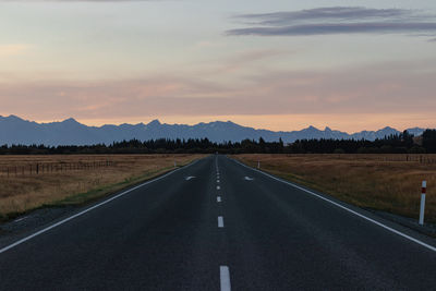 Empty road against sky during sunset