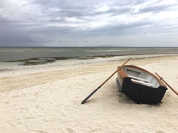 Scenic view of beach against cloudy sky