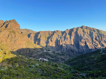 Scenic view of rocky mountains against clear blue sky