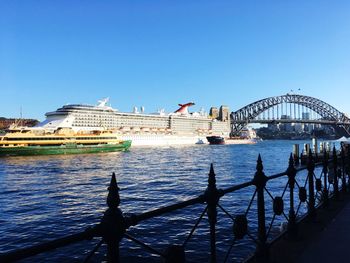 Bridge over river in city against blue sky