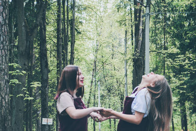 Side view of woman standing in forest