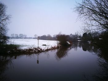 Scenic view of lake against sky during winter