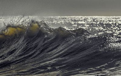 Close-up of waves on sea against sky