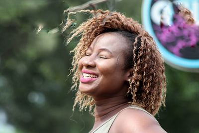 Smiling teenage girl with eyes closed in park