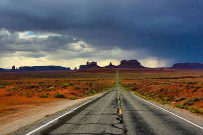 Road passing through land against sky