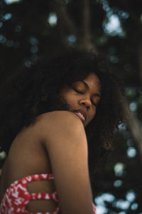 Close-up of young woman against trees