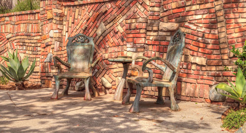 Chairs on brick wall