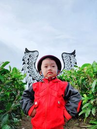 Boy standing on field against sky